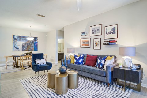 a living room with a couch and a chair and a dining room table